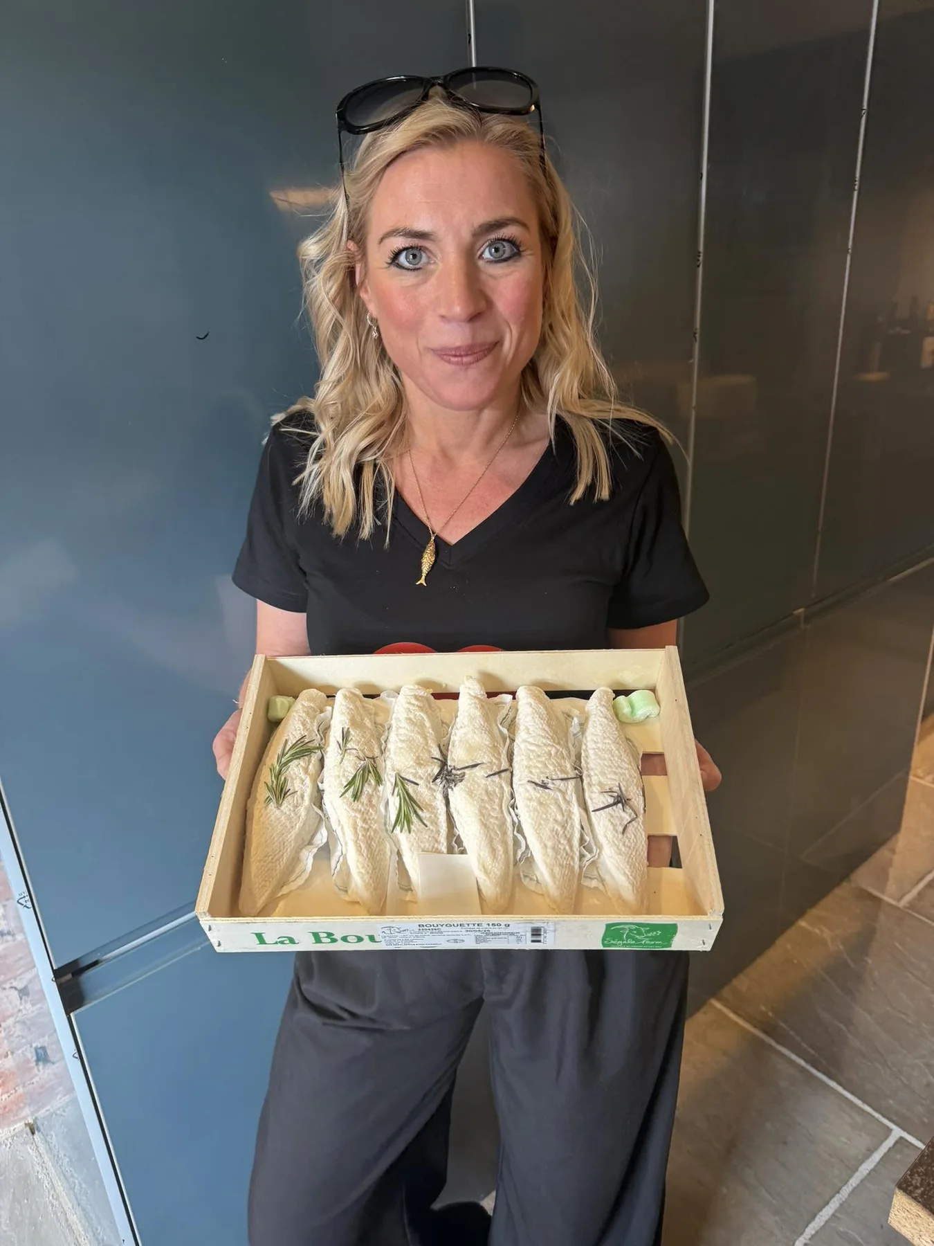 A member of the team holding a tray of newly arrived French goats’ cheeses