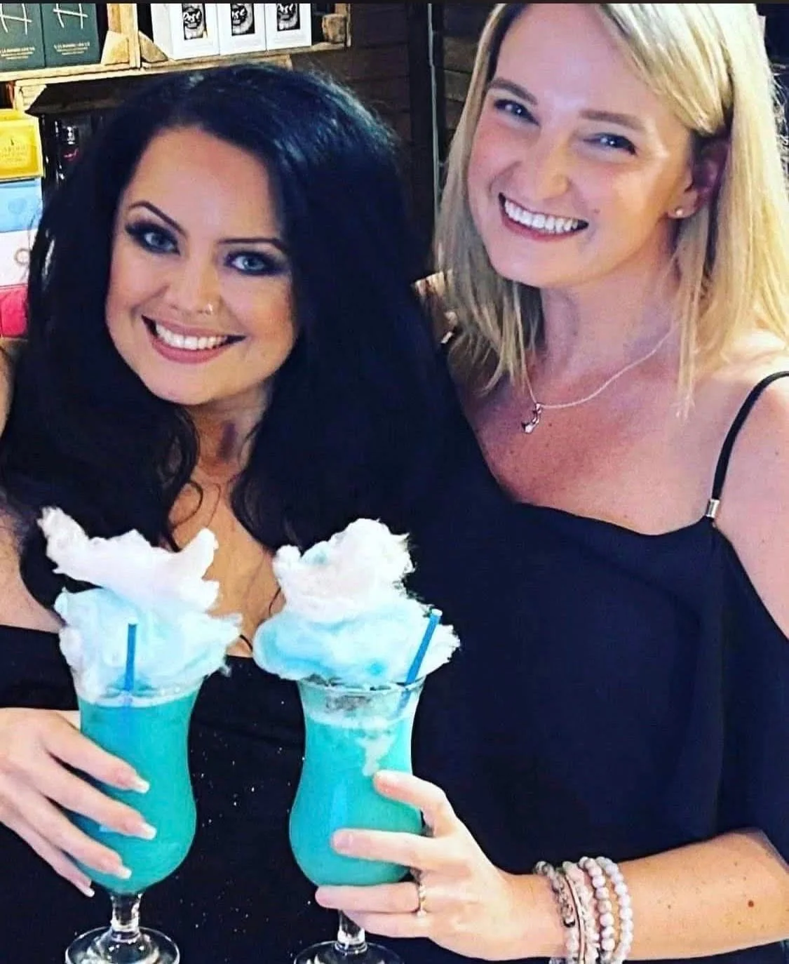 Two guests enjoying bright blue cocktails at Tipsy Cows