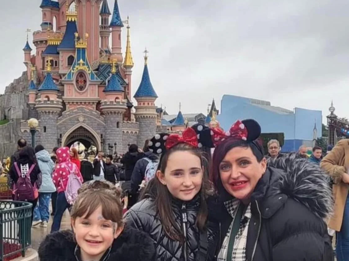 Guests in Minnie Mouse ears in front of the castle on the Nothing Is Impossible Disneyland Paris trip