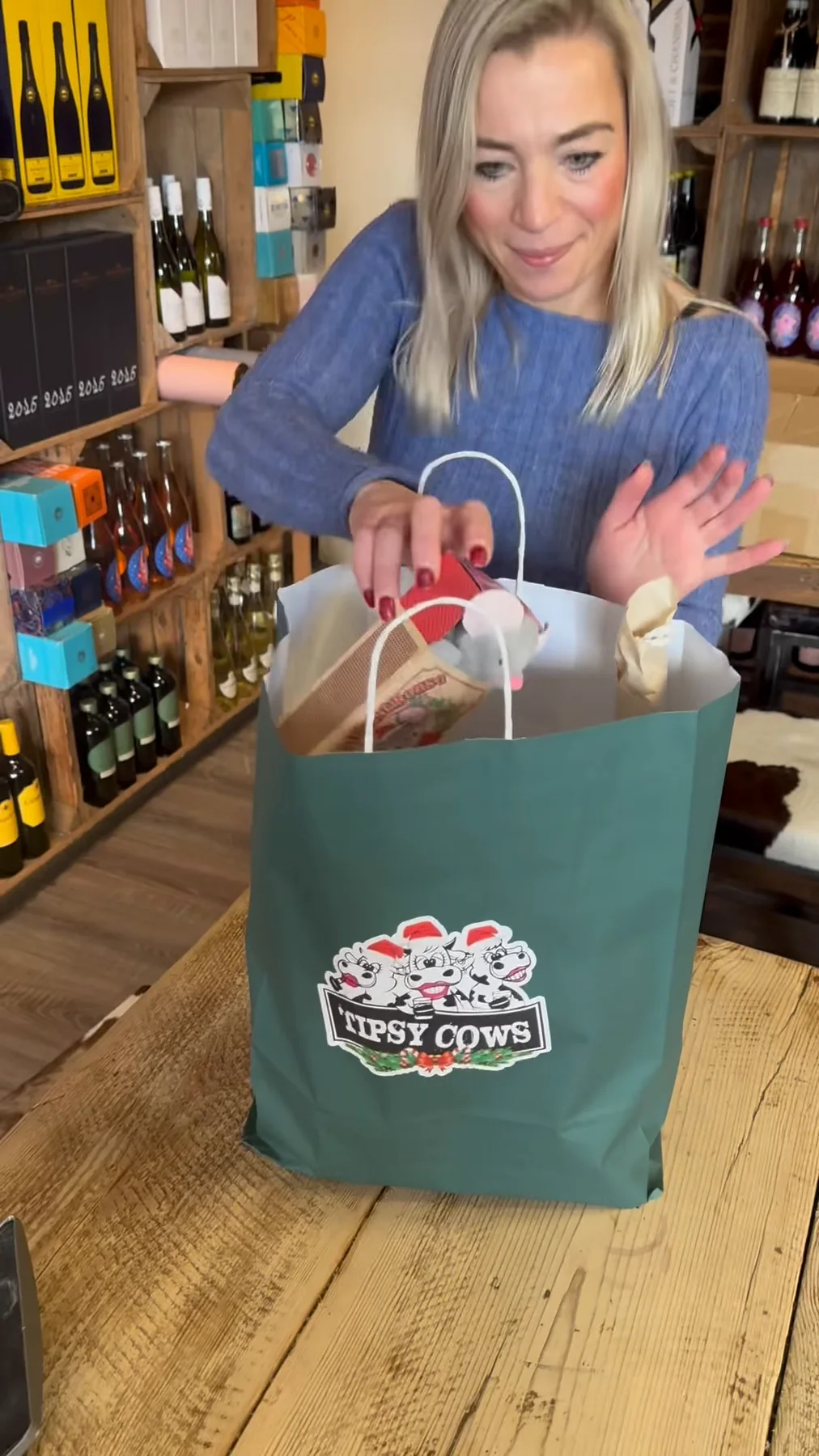 A member of the Tipsy Cows team packing a branded gift bag